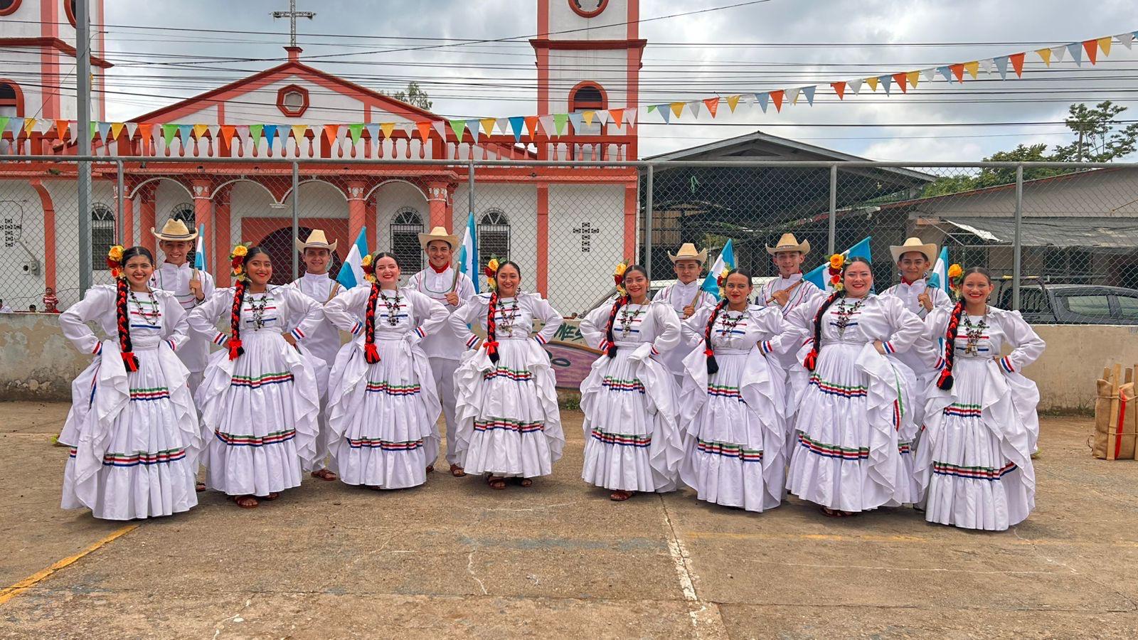 Grupo con trajes blancos y banderas